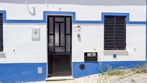 A building with a white and blue facade, a black door, and a window with shutters. - #197 Casa Gili by Home Holidays (Albufeira)