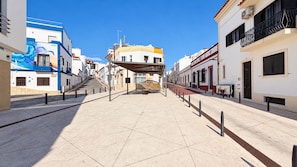 A wide, open pedestrian area with a clear sky, leading to a building with a blue and white facade. - #197 Casa Gili by Home Holidays (Albufeira)