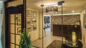 Un intérieur moderne comprenant un coin repas, un lustre et une cloison en verre.