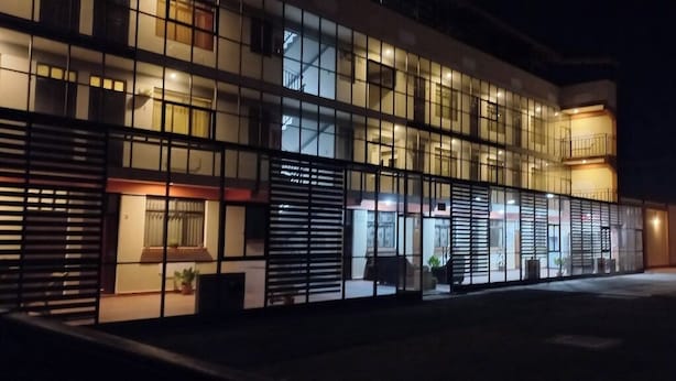 A modern building with large windows and a balcony. - Hotel Cesare (Uyuni)