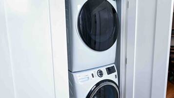 A stacked washer and dryer unit in a white cabinet.