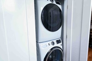 A stacked washer and dryer unit in a white cabinet.