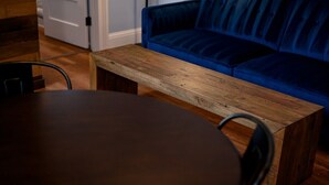 A wooden table and a blue sofa in a room with wooden flooring. - Governors Apartment -  2 bedroom  - Steps to FQ (New Orleans)