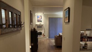 A hallway with a patterned rug, a bench, and a dining area with a table and chairs. - Best Value. Large 2 Bedroom Condo in Bigfork, Montana. Perfect Summer Getaway!  (Bigfork)