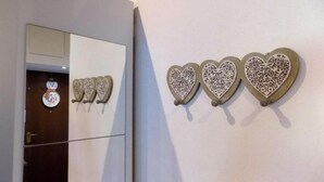 Un pasillo con un espejo que refleja una puerta y una decoración de muñeco de nieve.