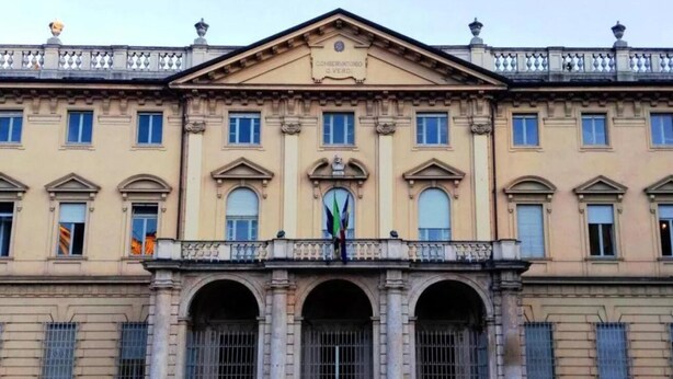Un edificio clásico con fachada simétrica, ventanas arqueadas y una entrada central con arco decorativo.