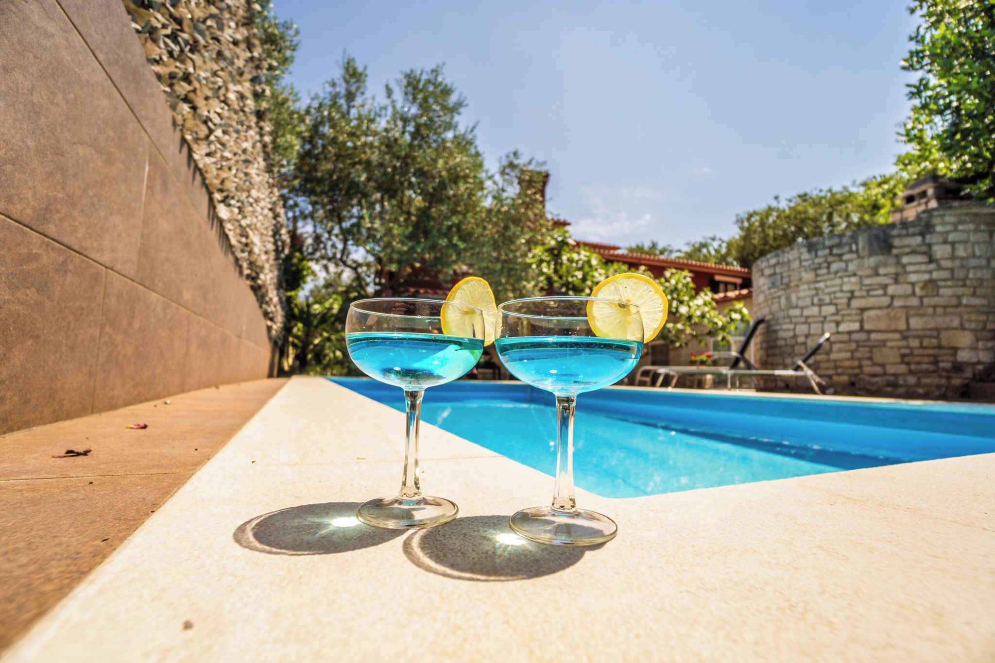 Zwei blaue Cocktails mit Zitronenscheiben auf einem Tisch am Pool.