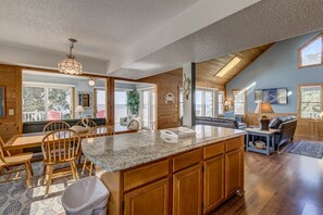 Spacious interior with a high ceiling, island kitchen, and comfortable seating area.