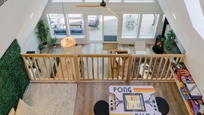 Ein geräumiges Loft mit hoher Decke, großen Fenstern und einem Tischtennis-Tisch.