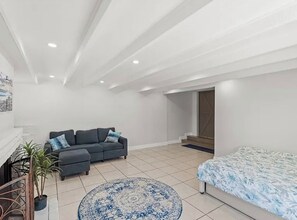 Un salón amplio con un sofá, un tapete redondo y una cama.