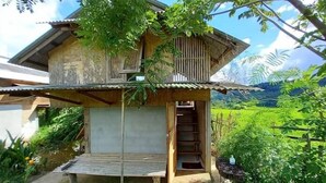 A rustic wooden house with a balcony and a staircase leading to a second floor. - Chinopuu Hut Homestay  (Chiang Dao)