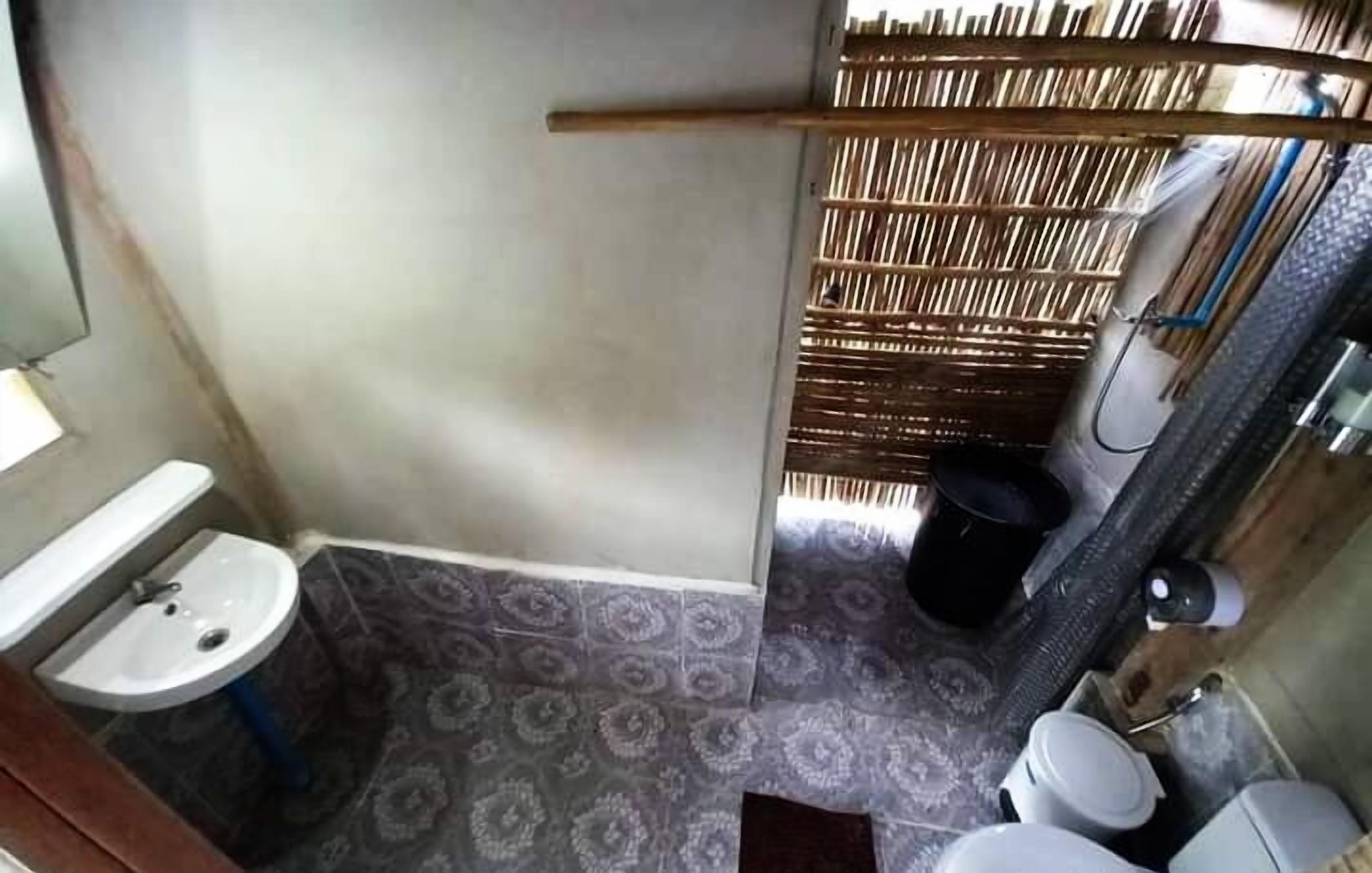 A bathroom with a toilet, sink, and shower area.