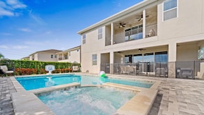 A two-story house with a swimming pool, outdoor seating, and a covered patio area. - Fruit Ninja Arcade, Fast and Furious Racing, Space Bedrooms, Theater, Pool Table: Cosmic Way (Kissimmee)