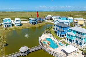 A coastal residential area with houses, a swimming pool, and a dock.