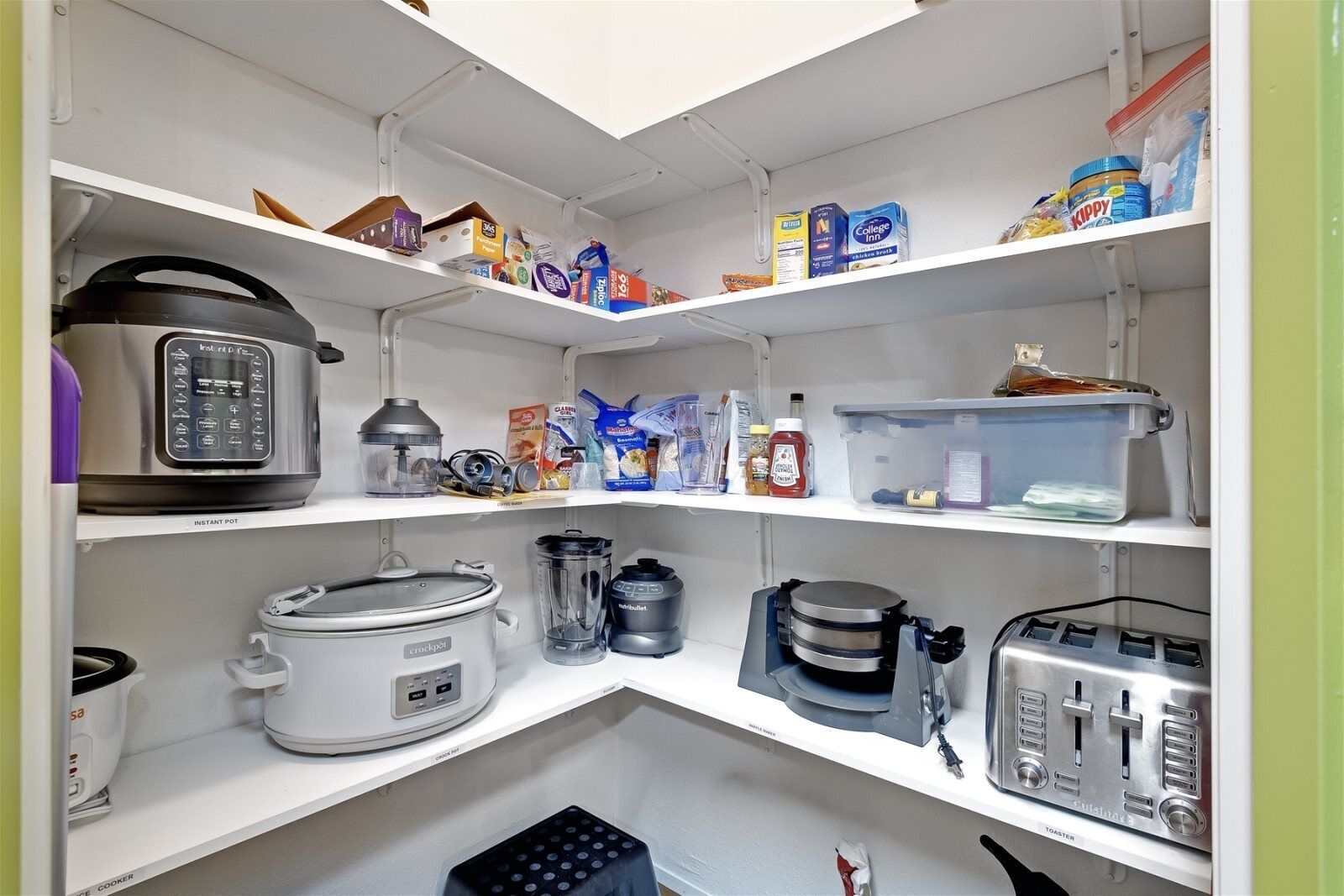Una cocina bien organizada con varios electrodomésticos y recipientes de almacenamiento.