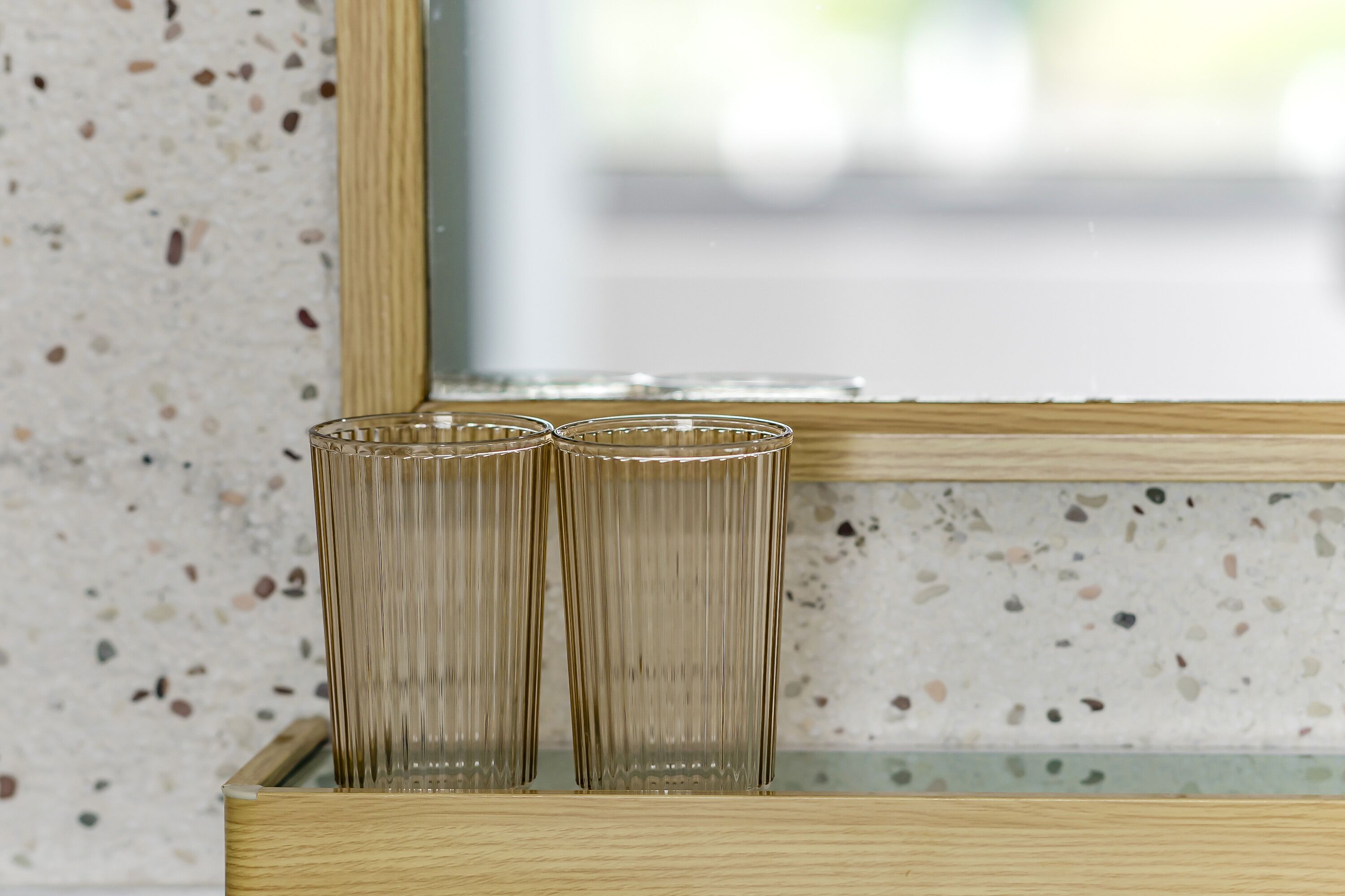 Three tall, clear glass vases in a wooden display cabinet.
