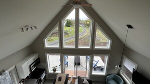 Cozinha moderna com uma janela grande, ventilador de teto e área de refeições com vista para o exterior.