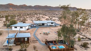 A desert resort with multiple cabins, a swimming pool, and a patio area. - Desert Playground - hot tub, dipping pool, hammocks, stargazing, dog friendly! (Twentynine Palms)
