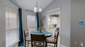 A dining area with a round table, chairs, and a chandelier. - Modern Comfort Lux Stay | Near DFW Airport (Euless)