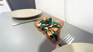 A table with a glass bowl containing dried flowers, a spoon, and a fork. - Captivating 1-Bed studio in Birmingham (Birmingham)