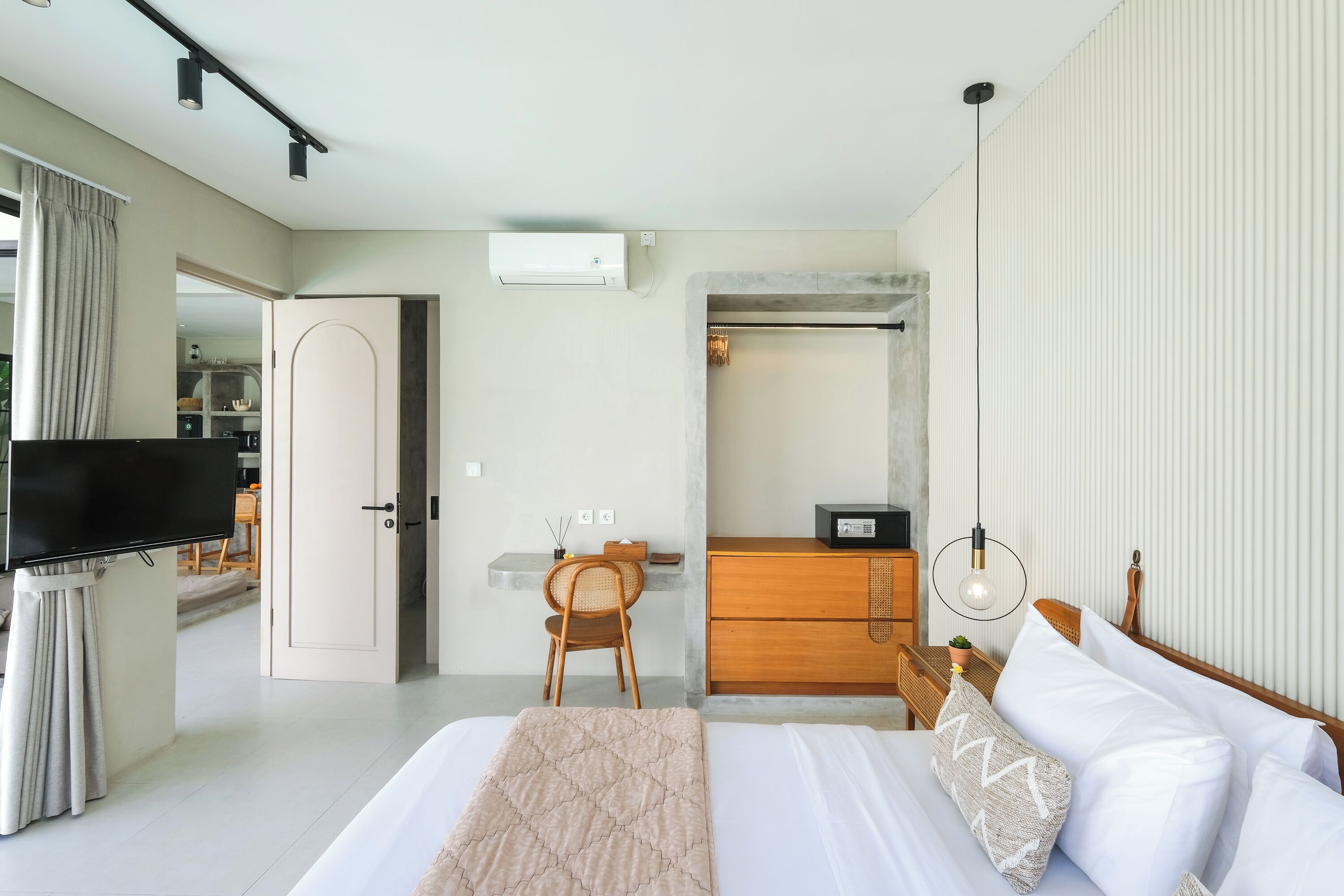 Ein modernes Schlafzimmer mit Bett, Nachttisch und Fernseher.
