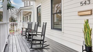 A porch with a rocking chair and a table, a mailbox, and a house number 543.