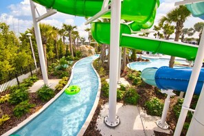 A water park with multiple water slides, a pool, and surrounding greenery. - New - Windsor Island - Sleeps 26 (Davenport)