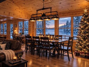 A cozy cabin interior with a dining area, wooden furniture, and a Christmas tree.