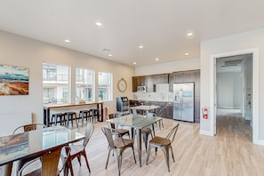 A spacious kitchen with modern appliances, a dining area with glass-top tables, and large windows providing natural light. - Enchanting townhome with pool, hot tub, fire pit, games, & great balcony views (Santa Clara)