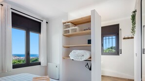 Une chambre avec un lit, une vue sur la mer, une bibliothèque intégrée et un radiateur.