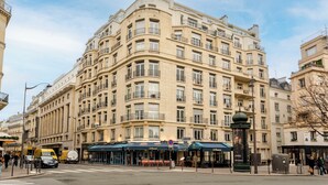 A multi-story hotel with a classic architectural design, featuring balconies and large windows. - Merveil Signature Suite Hoche - Eiffel Tower view (Paris)