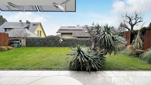 A residential backyard with a patio, a lawn, and a hedge. - Apartment 'Haus Loser' with Private Terrace, Shared Garden and Wi-Fi (Wasserburg (Bodensee))