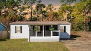 A single-story mobile home with a porch, a small front yard, and a wooden fence. - Completely remodeled 3BR/2BA,PET friendly,5min from Hurlburt Field,fully fenced  (Mary Esther)
