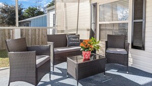 An outdoor patio with wicker furniture, a glass coffee table, and a potted plant. - Completely remodeled 3BR/2BA,PET friendly,5min from Hurlburt Field,fully fenced  (Mary Esther)