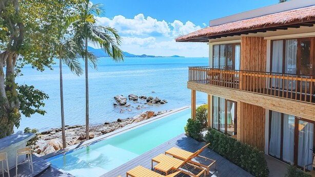 A modern resort with a pool, wooden deck, and a view of the ocean. - Sea Sun Bed & Beyond (Koh Samui)