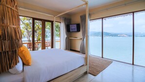 A bedroom with a large bed, a TV on the wall, and a view of the sea. - Sea Sun Bed & Beyond (Koh Samui)