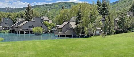 A lakeside resort with multiple buildings, a dock, and a grassy area.