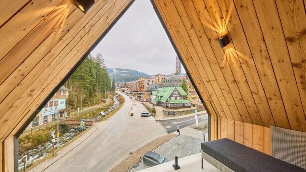 A room with a sloped ceiling, a view of a town, and a bench. - Rooftop Vista Maisonette & Relaxing Bath by Interhome (Pec pod Snezkou)