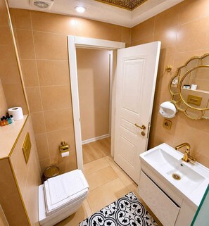 A bathroom with a toilet, sink, and shower.
