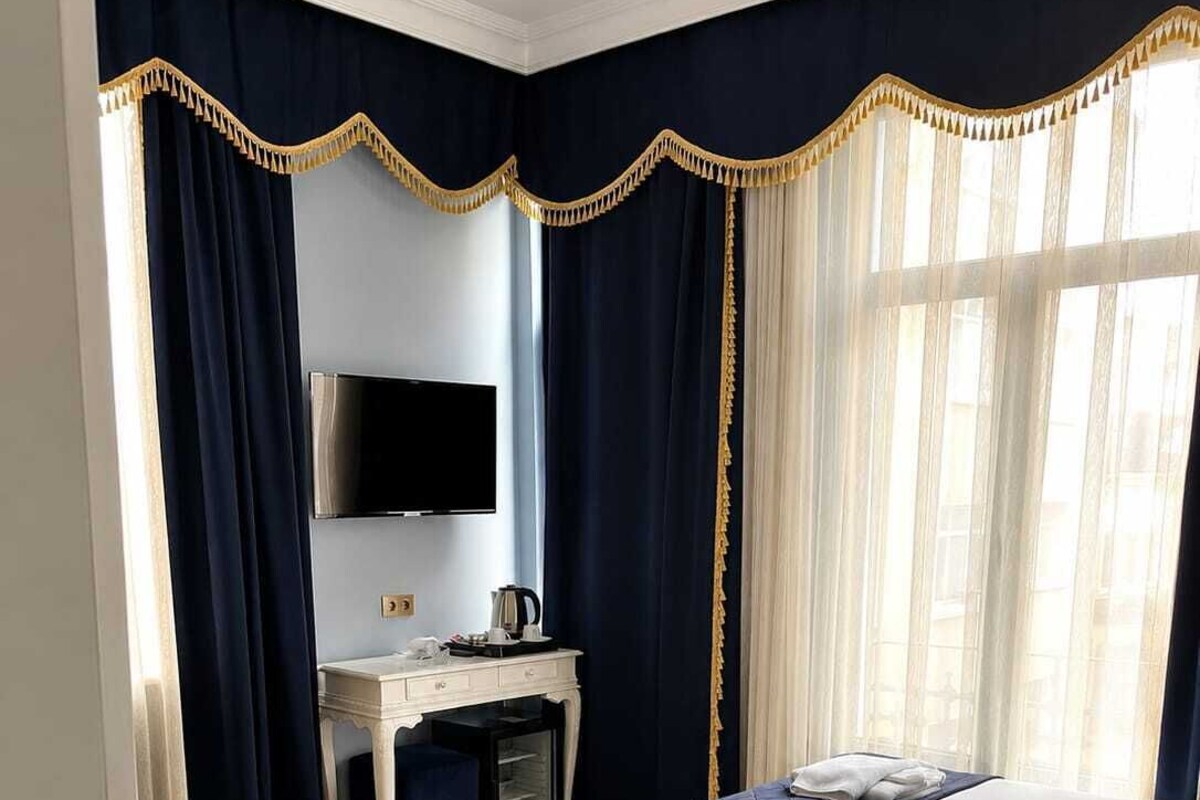 Una habitación de hotel con dos camas, un escritorio con televisor, teléfono y cafetera.