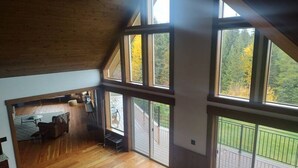 A spacious loft with high ceilings, large windows, and a wooden floor. - Ponderosa Glen @ Ashley Lake (Kila)