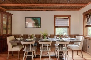 A dining area with a wooden ceiling, a large painting, and a table set for four. - Ponderosa Glen @ Ashley Lake (Kila)
