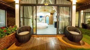 A modern villa with a glass-enclosed bedroom, a hot tub, and wicker chairs outside. - Apple House & Coffee (Ho Chi Minh City)