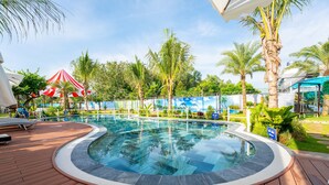 A pool area with a hot tub, palm trees, and lounge chairs. - Apple House & Coffee (Ho Chi Minh City)