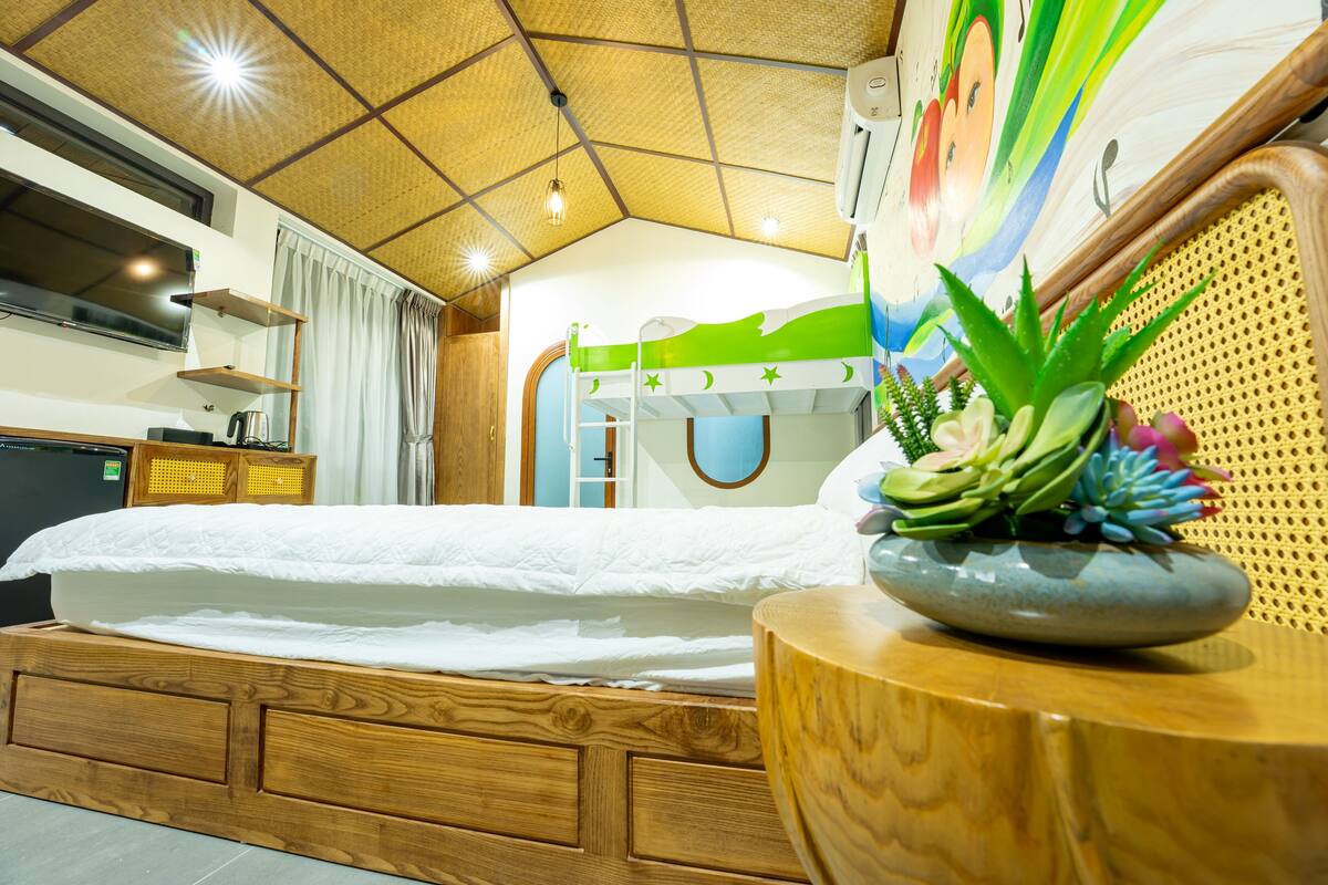 A room with a bunk bed, wooden furniture, a decorative wall, and a ceiling with a geometric pattern.