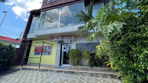 A building with a sign reading "BnT Inn" and a contact number. - BnT Inn Cebu powered by Cocotel (Lapu-Lapu)
