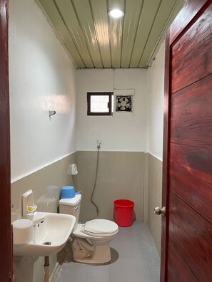 A small bathroom with a toilet, sink, and shower. - BnT Inn Cebu powered by Cocotel (Lapu-Lapu)