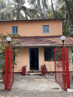 Stunning two-story building with a flat roof and tiled exterior, featuring a single entrance with a door and a window above.