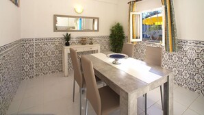 A dining area with a table, chairs, a mirror, and patterned walls.