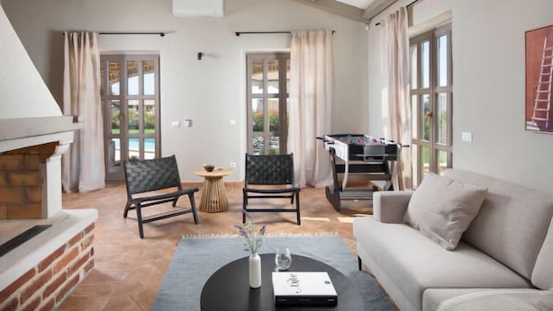 A spacious living area with a fireplace, a sofa, a coffee table with a book, and a foosball table. - Vacation home Seseli by Interhome (Poreč/Sv. Lovreč)